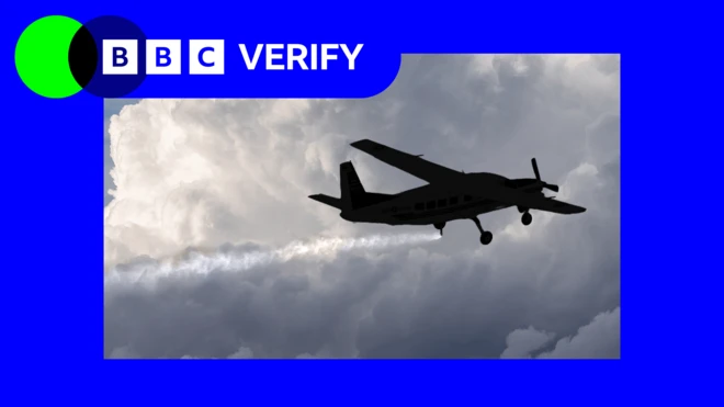 Küçük bir uçağın silüeti gökyüzüne ince parçacıklar püskürtürken görülüyor; arkasında uzun bir beyaz iz bırakıyor. Arka planda yoğun gri bulutlar var. Görüntünün sol üst köşesinde BBC Verify logosu yer alıyor.