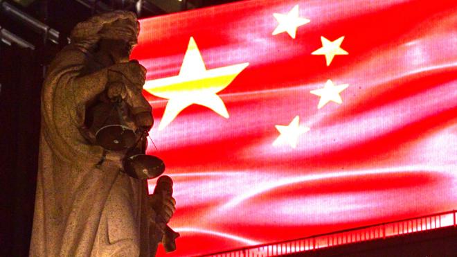 香港终审法院大楼楼顶正义女神像映照在一面投射在LED屏幕的中国国旗下（30/9/2019）