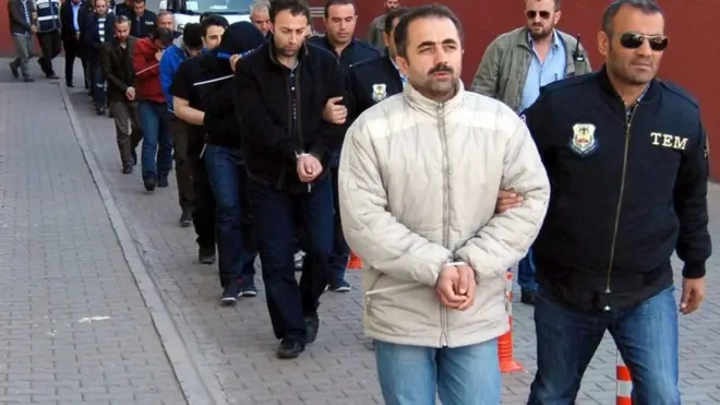 Сотрудники турецкой полиции сопровождают задержанных в ходе масштабных операций