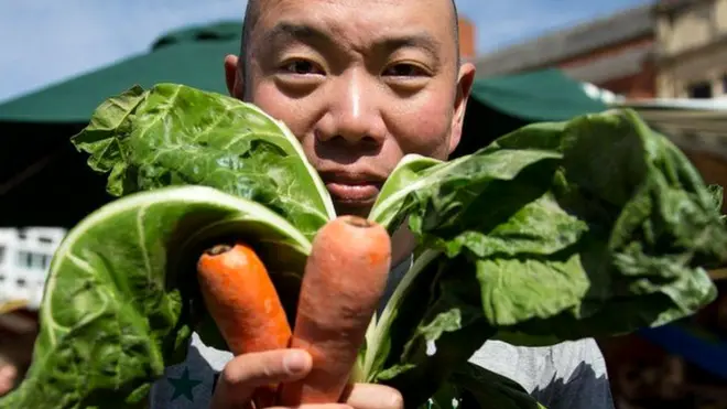 క్యారెట్‌ చేతిలో పట్టుకున్న వ్యక్తి