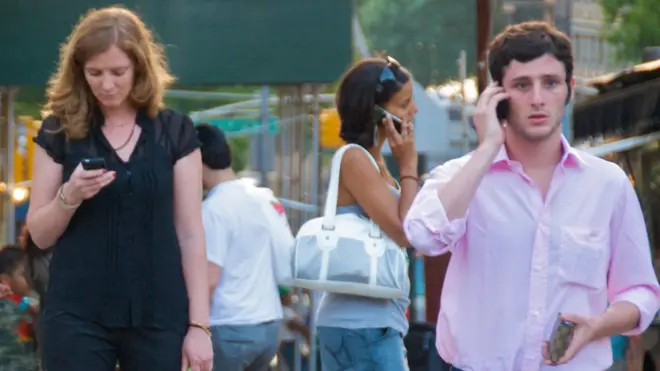 Para milenial dewasa sedang menggunakan ponsel pintar.