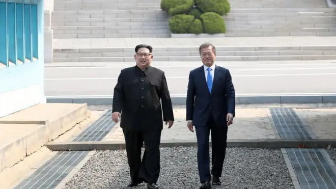 Серый бетонный бордюр за спиной у Кима и Муна и есть граница между двумя разными мирами: коммунистической КНДР и капиталистической Республикой Корея