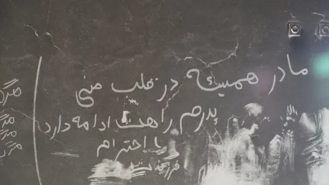 فرزندی که مادر و پدرش را از دست داده، روی دیوار سوخته مسجد یادگاری نوشته است