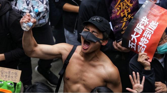 香港民主派元旦游行一名赤膊上身的男子高举右手大喊口号（1/1/2020）