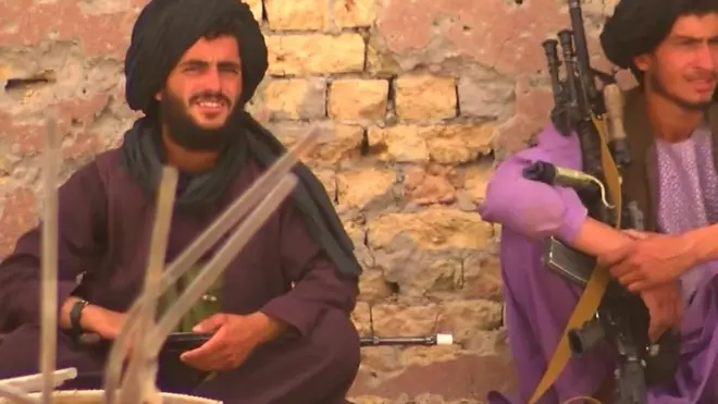 ผู้ชายนั่งถือปืน