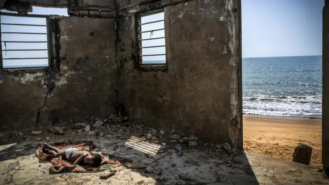 طفل نائم داخل مبنى مهجور على شاطئ غانا في عام 2019