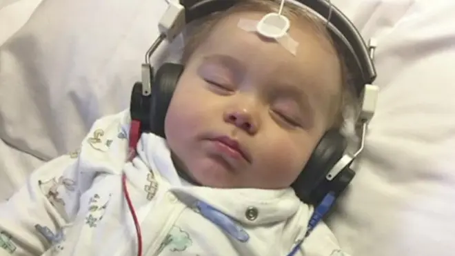 Годовалый ребенок Макс в наушниках