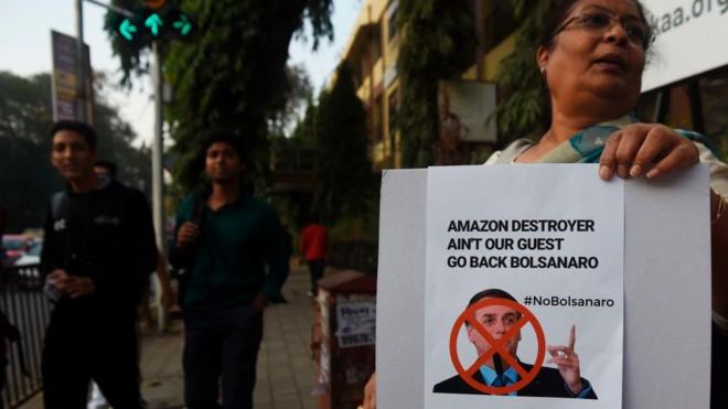 'Destruidor da Amazônia não é nosso convidado. Volte para casa, Bolsonaro', diz cartaz de protesto em inglês durante a visita do presidente brasileiro à Índia, em janeiro de 2020