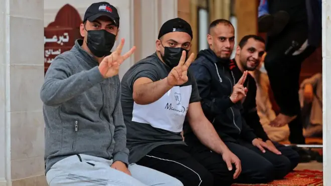 Palesitnian Muslim worshippers flash di V-sign for victory during di morning Eid al-Fitr prayer