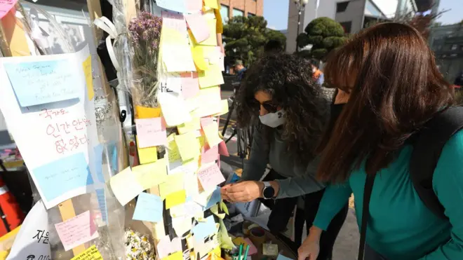 11일 서울 용산구 이태원역 1번 출구에 마련된 이태원 참사 희생자 추모공간에서 외국인들이 희생자를 애도하고 있다