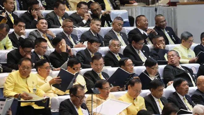 ผบ. เหล่าทัพที่ได้รับแต่งตั้งให้เป็น ส.ว. โดยตำแหน่งถอดเครื่องแบบประจำ แล้วสวมสูทร่วมรับฟังการแถลงนโยบายของรัฐบาลต่อรัฐสภาเมื่อปลาย ก.ค. ที่ผ่านมา