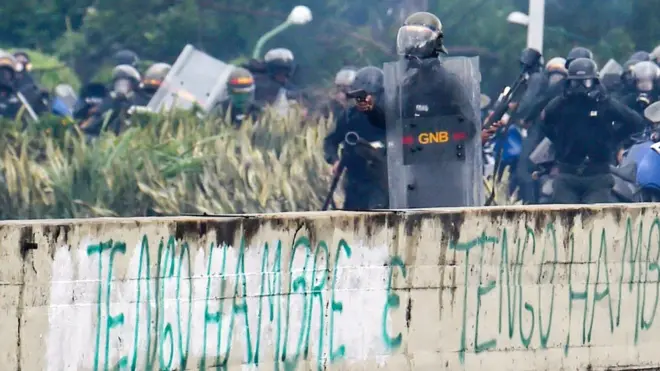 Agente de policía sosteniendo un arma.