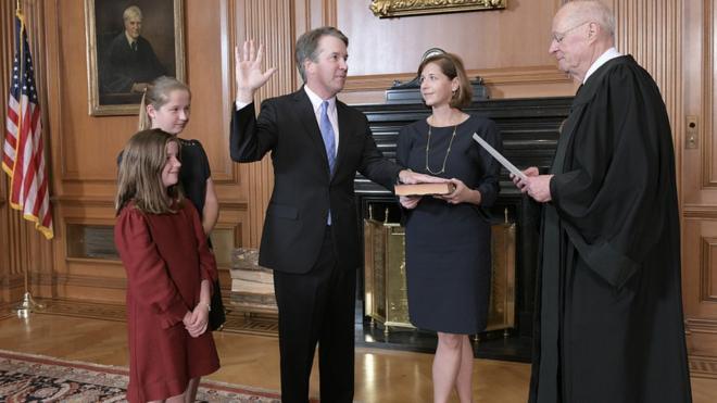Brett Kavanaugh, watched by his family, is administered the judicial oath by Justice Anthony Kennedy