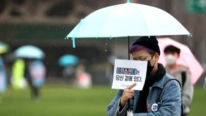 서울광장에서 열린 '변희수 하사를 기억하며-트랜스젠더 가시화의 날 공동 기자회견'에서 참석자들이 손팻말을 들고 기자회견을 지켜보고 있다