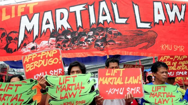 Para aktivis memprotes rencana perpanjangan keadaan darurat di depan istana kepresidenan di Manila.