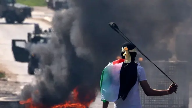 متظاهر فلسطيني يستخدم مقلاعا لإلقاء حجارة على قوات الأمن الإسرائيلية وسط اشتباكات وقعت خلال مظاهرةمناهضة للمستوطنات الإسرائيلية ومناصرة للمسجد الأقصى في قرية بيتا بالضفة الغربية المحتلة في 15 أبريل نيسان