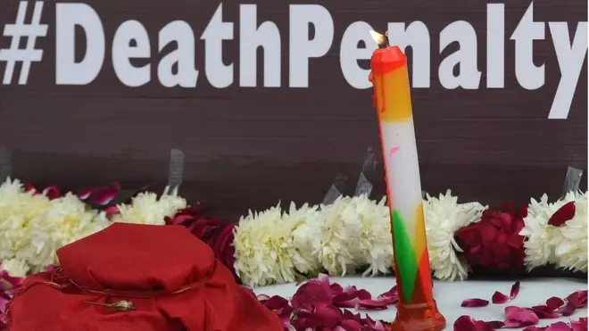 Candle at vigil against rape