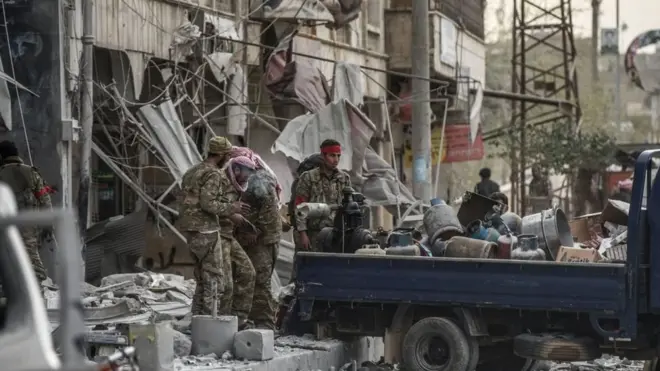 فصائل المعارضة من الجيش الحر الذين سيطروا على عفرين بعم من الجيش التركي يقومون بنهب متاجر مدينة عفرين في 18 مارس/آذار 2018.