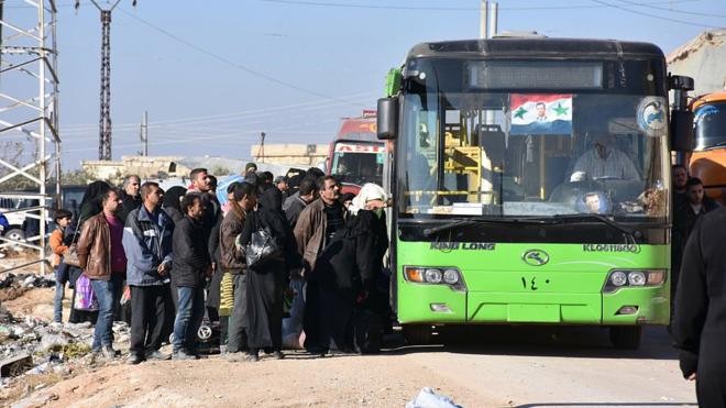 Civiles subiendo a un autobús en Alepo