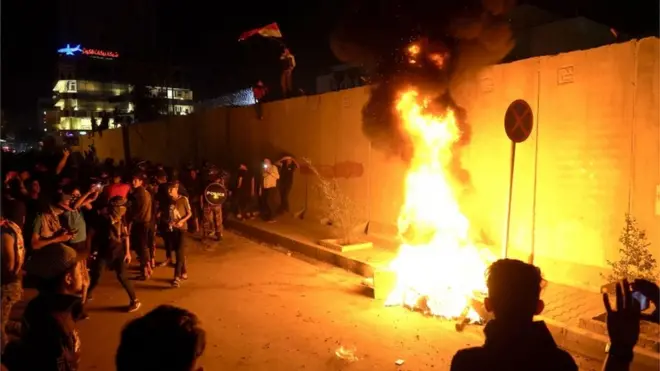Sejumlah demonstran Irak menyalakan api di luar tembok gedung Konsulat Iran di Karbala.
