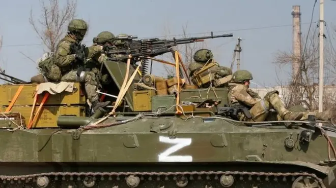 Service members of pro-Russian troops are seen atop of an armoured vehicle with a symbol "Z" painted on its side in the course of Ukraine-Russia conflict in the besieged southern port city of Mariupol, Ukraine March 24, 2022.