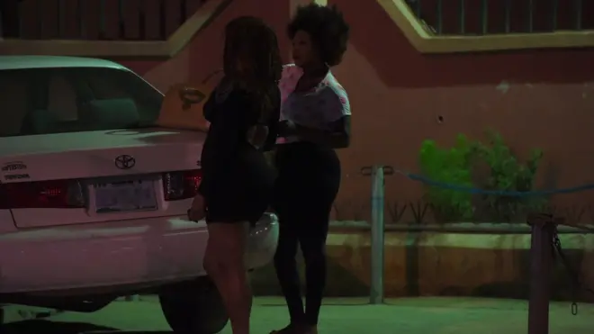 Prostitutes stand dey wait customers for Benin City, southern Nigeria on March 2017. Dem no dey call am prostitution, na 'hustling' dem dey call am.