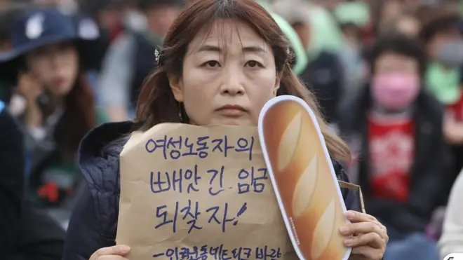 8일 오후 서울 종로구 덕성여대 종로운현캠퍼스 앞에서 열린 3.8 세계 여성의 날, 비정규직 여성 노동자 대회에서 참석자들이 메시지가 담긴 피켓을 들고 비정규직 차별 철폐와 최저임금 30% 인상을 촉구하고 있다