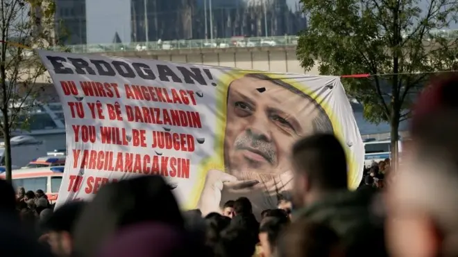 پلاکاردی که امروز تظاهرات کنندگان مخالف دولت ترکیه در آلمان به دست داشتند و روی آن نوشته شده بود: "تو (اردوغان) قضاوت خواهی شد"