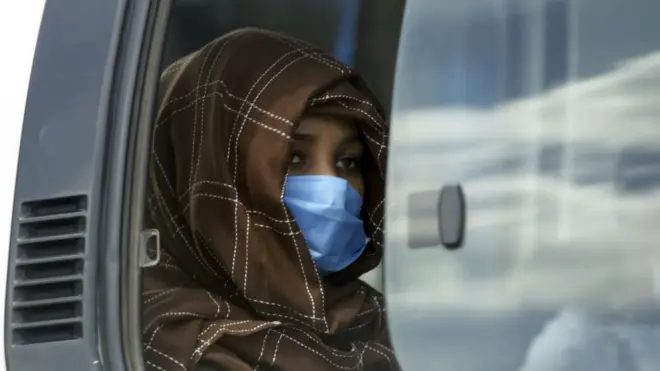 ጭምብል ያደረገች ወጣት መኪና ውስጥ