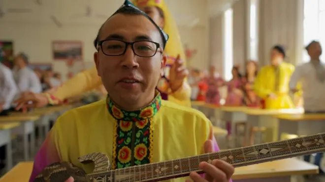 A man playing an instrument inside the camp