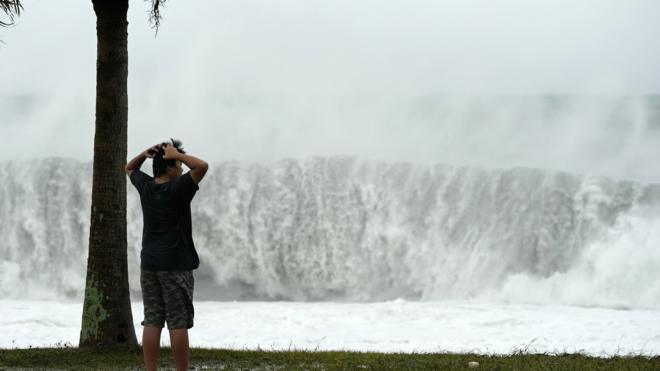 A boy looks at high waves generated by typhoon Hagibis in Atawa, Mie Prefecture, Japan, 12 October 2019.