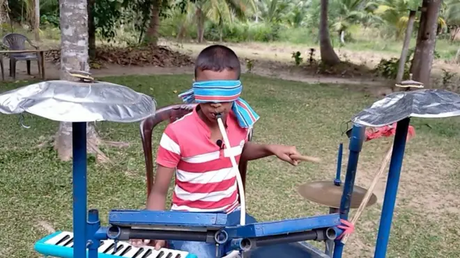 දෑස් බැඳ සංගීත භාණ්ඩ දෙකක් එකවර වාදනය කරන මලීෂගේ හැකියාව