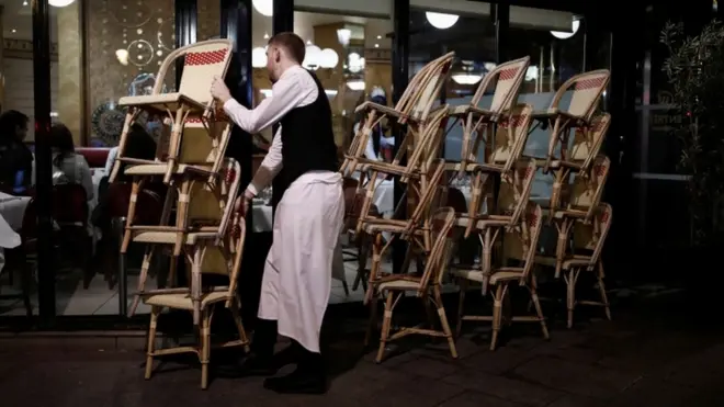 نادل يقوم بجمع المقاعد في مطعم بفرنسا