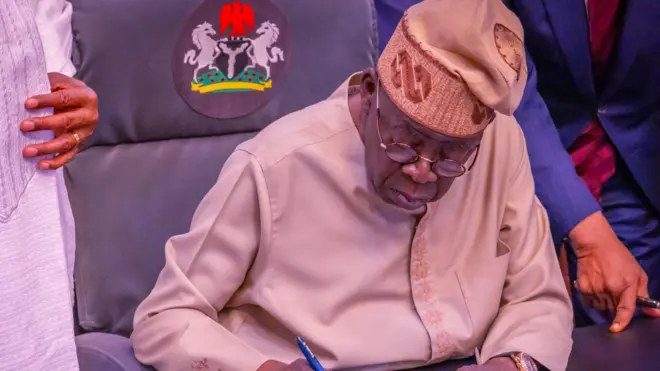 Tinubu on cap wit pen