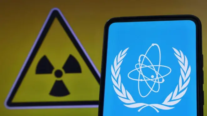 эмблема МАГАТЭ и знак ядерной опасности