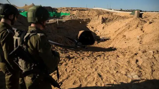 جنديان إسرائيليان يقفان قرب ما يقولان إنه مدخل نفق في غزة