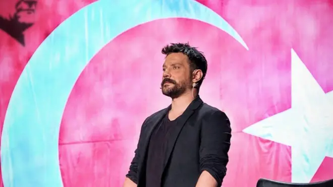 Oğuzhan Uğur, Türk bayrağının önünde ayakta duruyor
