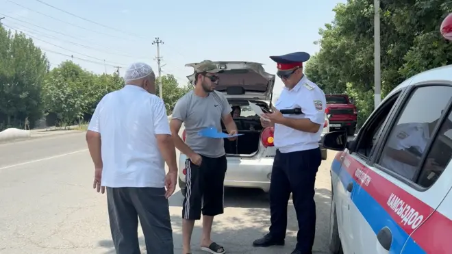 ЖКККББнын өкүлү таксисттин лицензиясын текшерип жатат