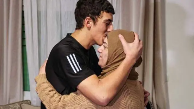 ইসরায়েলি কারাগারে বন্দি মুহাম্মদ আবু আল-হুমুস, সোমবার রাতে পূর্ব জেরুজালেমে তার বাড়িতে ফিরে তার মাকে চুম্বন করেন।