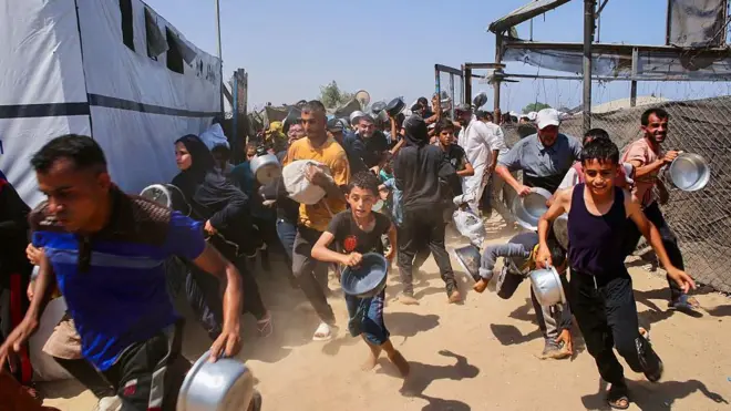 فلسطينيون يصطفون أمام مطبخ خيري لتلقي مساعدات غذائية