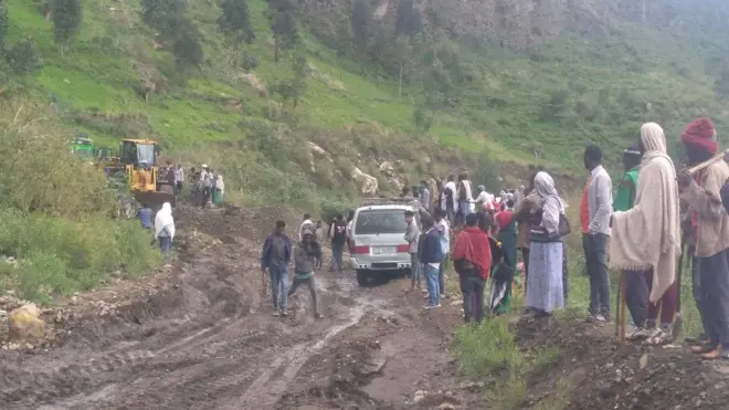 በአስቸጋሪ መንገድ ላይ ያለ ተሽከርካሪ እና ተሳፋሪዎች 