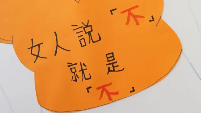 2011年香港“七一游行”上,一位呼吁保障女性权益的游行人士举起剪裁成女性上衣形状的标语牌,上面写着:“女人说‘不’就是‘不’”