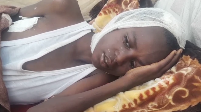 Ahmed Abdul Rahman est allongé sur une couverture, vêtu d'un gilet et couvert de bandages.