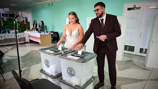 Жених и невеста голосуют на избирательном участке в селе Хорешты