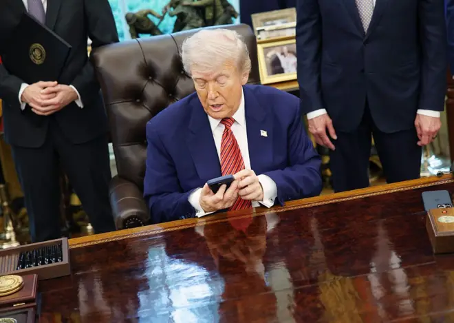 Trump mexendo no telefone