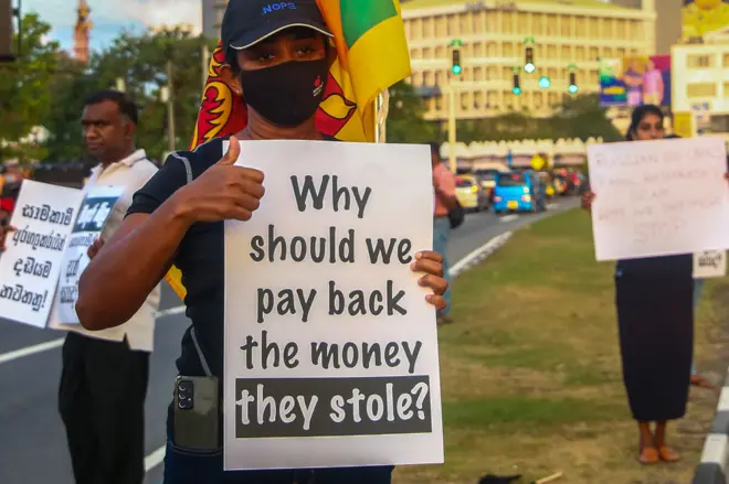 Protestors hold placards as they take part in an anti-government demonstration in Colombo on September 25, 2022. 