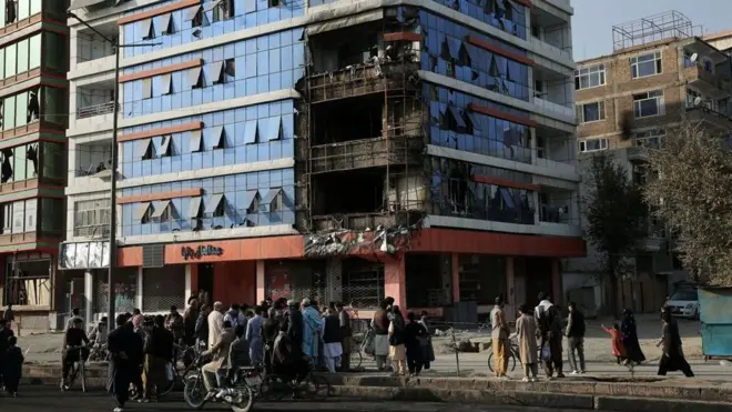 16 اکتوبر 2025 کو لی گئی تصویر میں کابل میں مبینہ پاکستانی فضائی حملوں کے بعد شہری تباہ شدہ عمارت کا جائزہ لے رہے ہیں۔