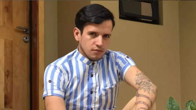 Andry Hernández sentado frente a una casa.