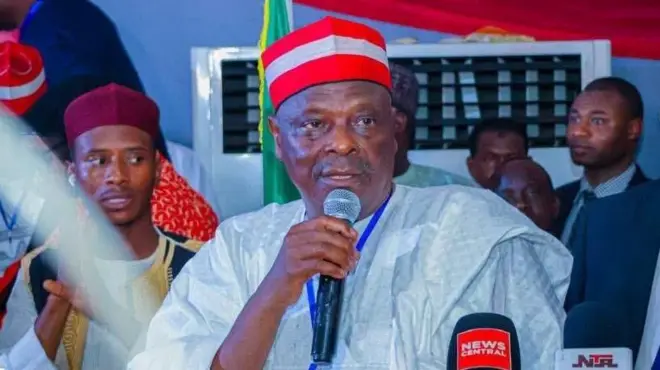 Rabiu Kwankwaso wọ agbádá funfun, ó dé fìlà pupa, ó mú gbohùngbohùn dání