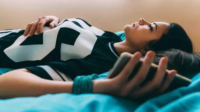 ผู้หญิงนอนบนเตียง